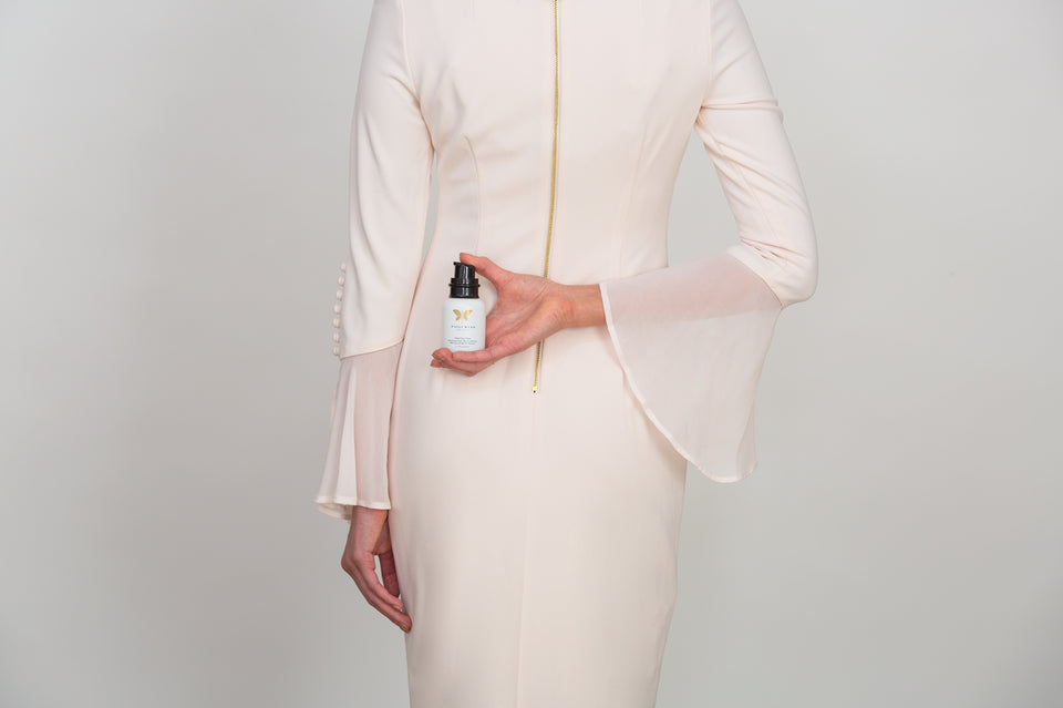 A Model Holds a Bottle - Paige Ryan Beauty